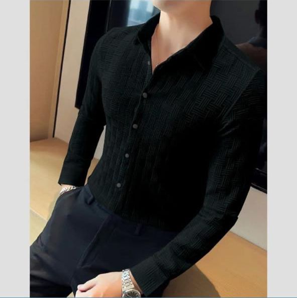 Person wearing a black textured shirt sitting on a couch.